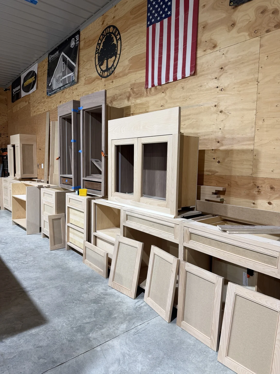 Unfinished custom cabinet fronts and components arranged in the Stimis workshop