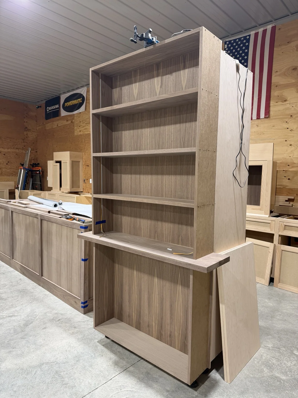 Tall unfinished cabinet assembly with shelving in the Stimis workshop