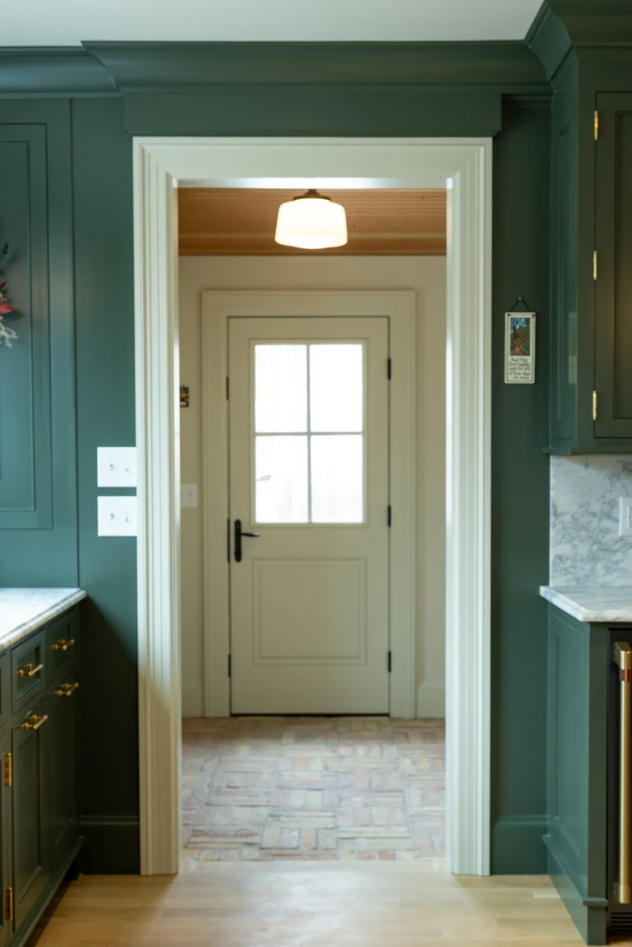 Deep green paneled passage framing an entry door