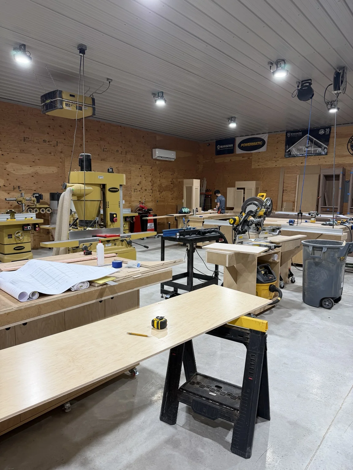 Stimis workshop interior with machinery, panels and an active workbench